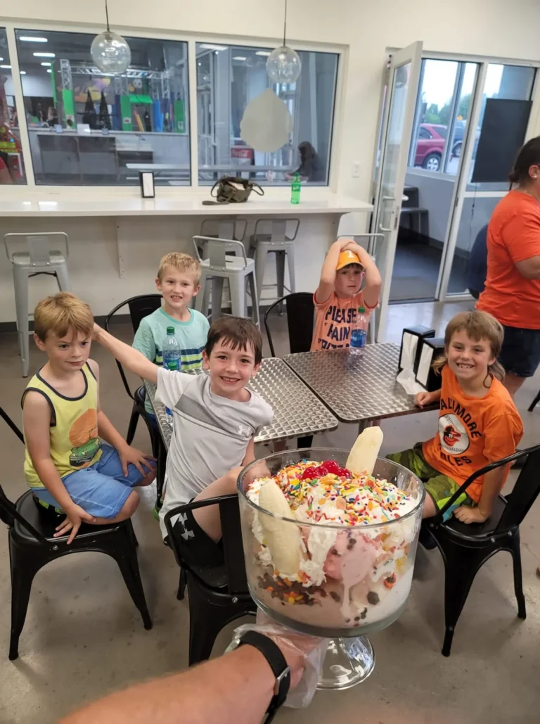 Kids sharing a big sundae at a table in Tots Ice Cream