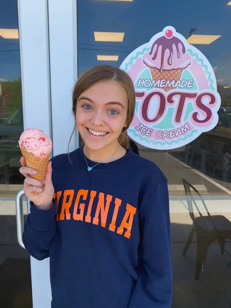 Happy customer holding a pink ice cream cone at Tots