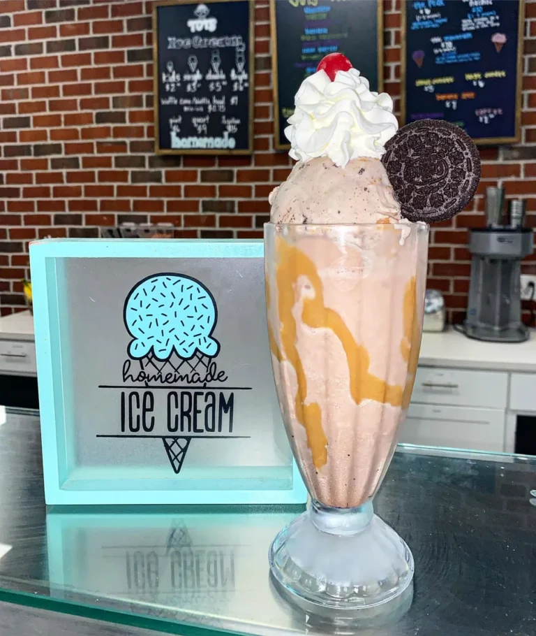 Milkshake topped with whipped cream, caramel and a cookie on the Tots counter