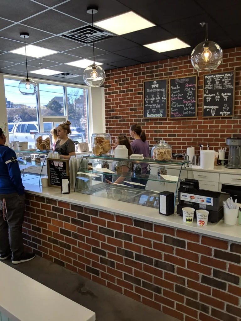 Inside Tots Ice Cream in Penn Laird: brick counter, dipping case and chalkboard menus